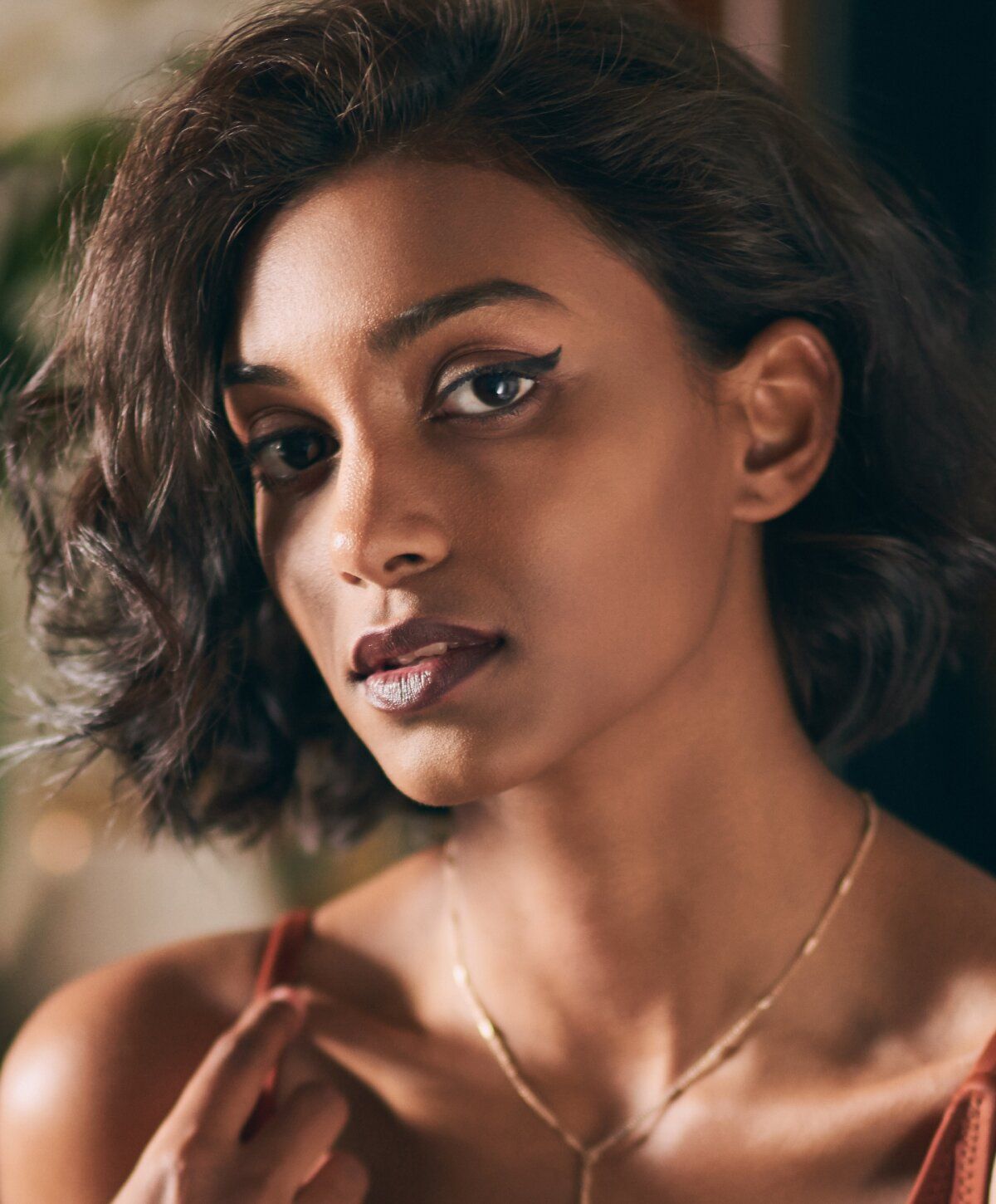 Woman with thoughtful expression and soft makeup.