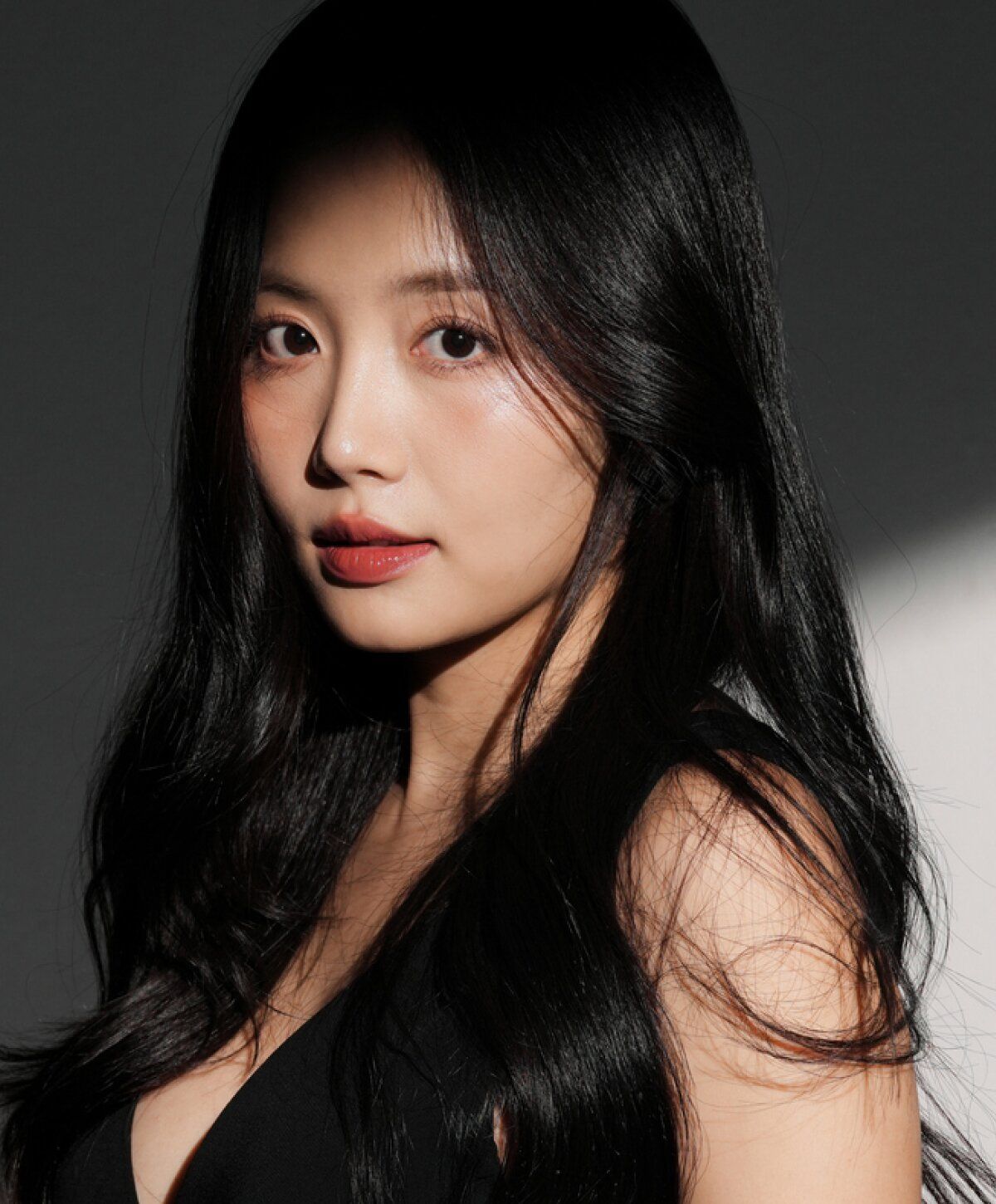 Woman with long black hair and natural makeup.