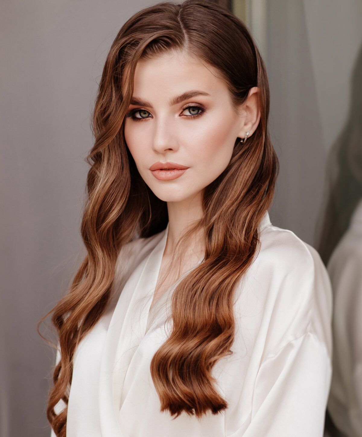 Woman with long wavy hair wearing a silk robe.