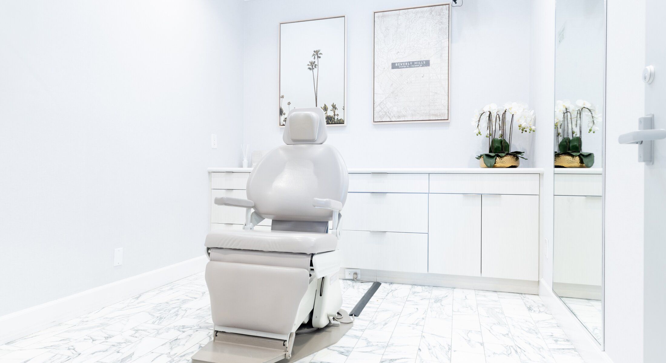 Dental treatment room with adjustable chair and decor.