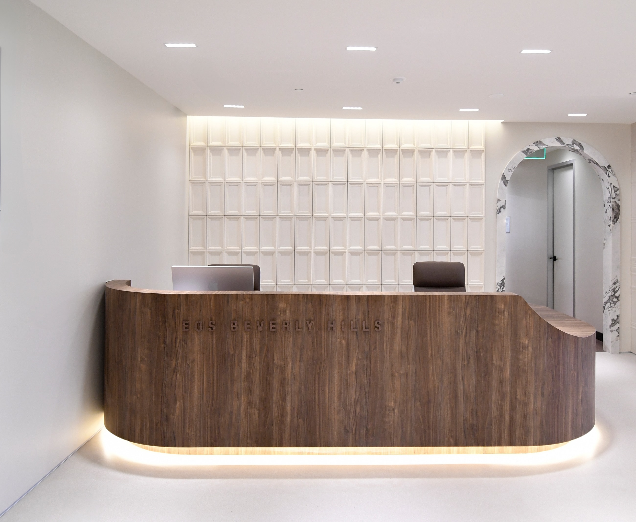 Modern reception area with curved wooden desk.