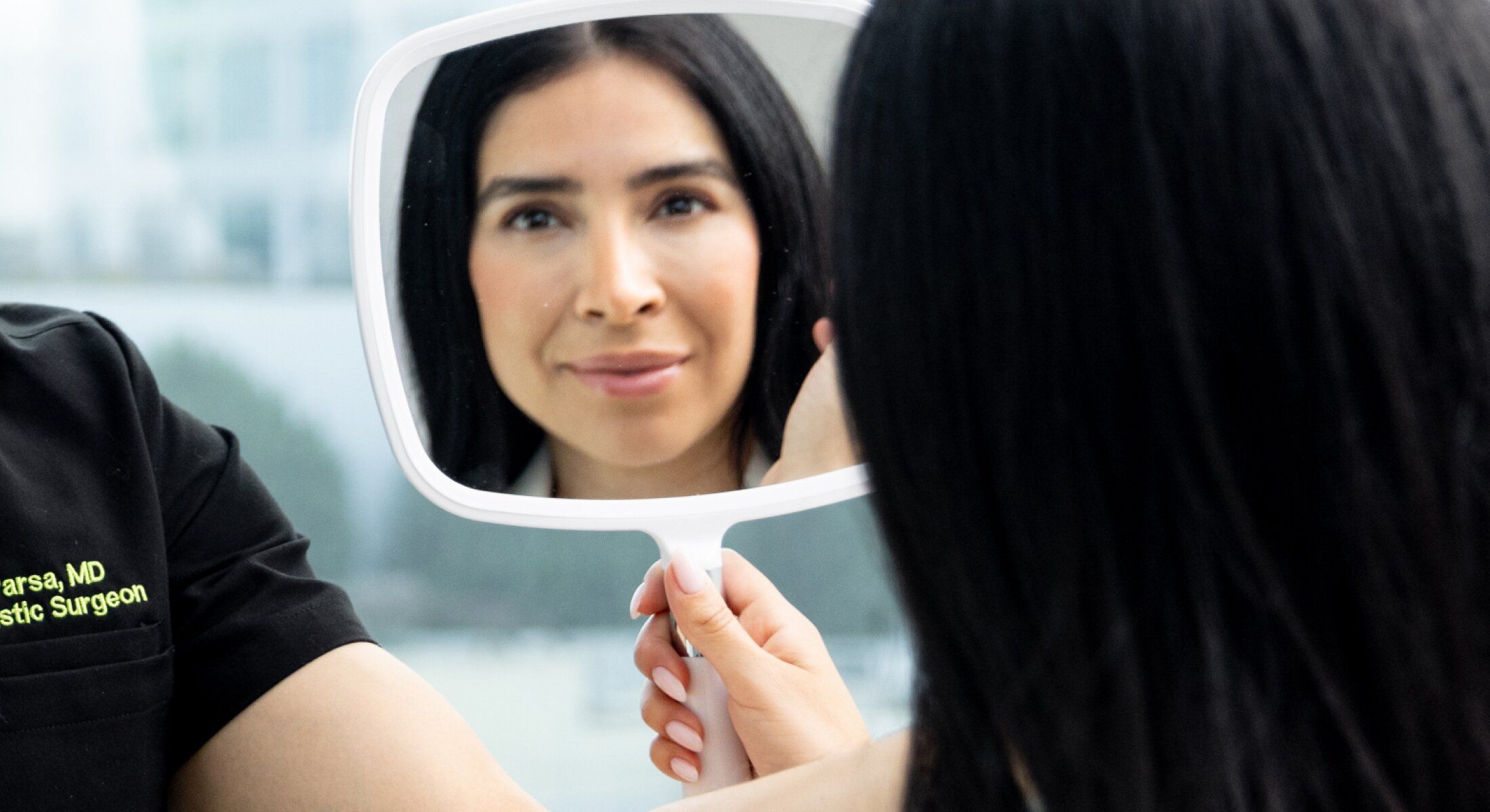 Woman looking in a mirror, evaluating her reflection.