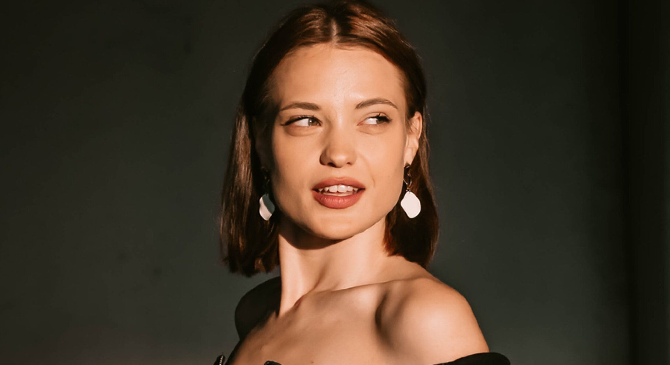 Model with short hair and elegant earrings.