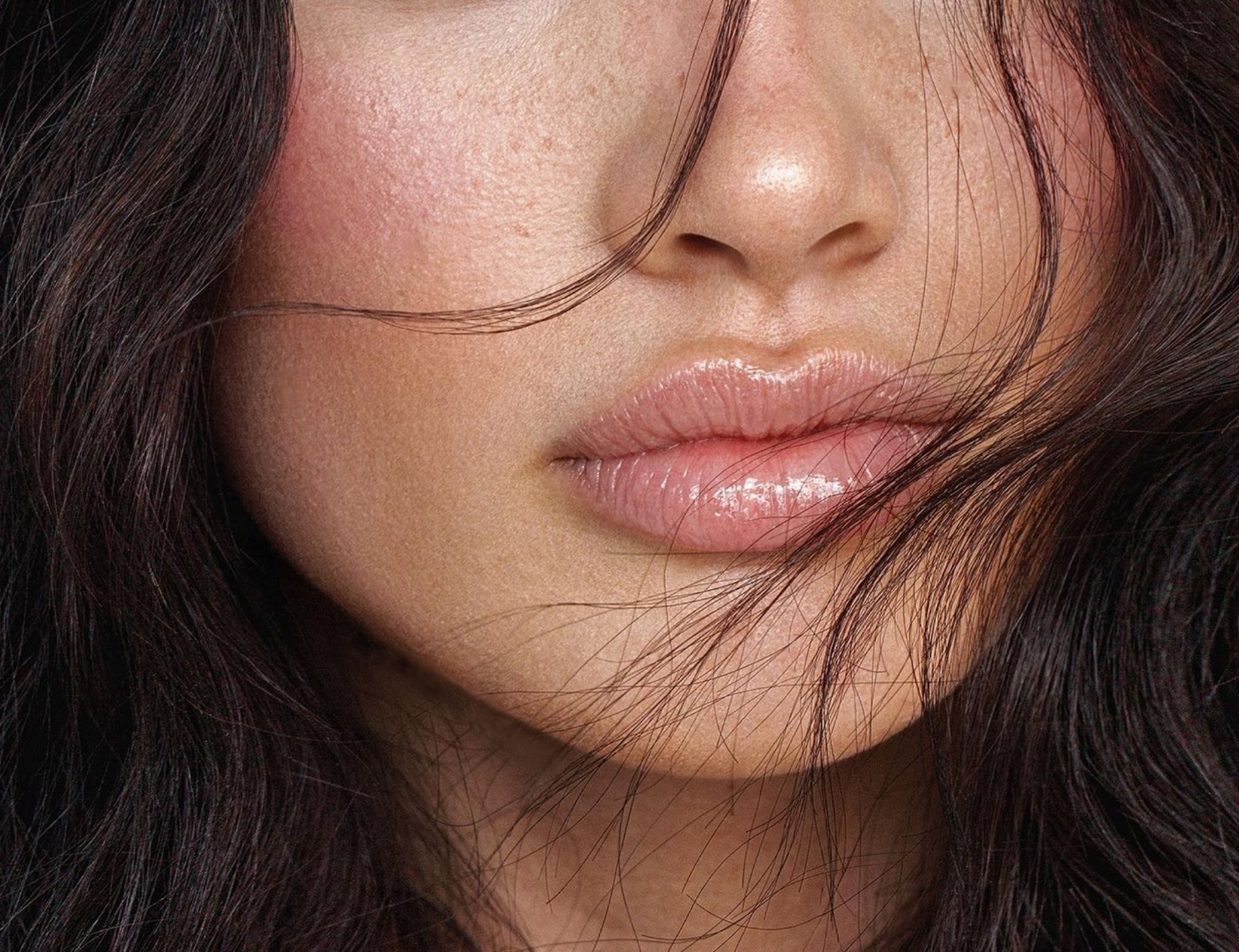 Close-up of lips and cheek with hair.