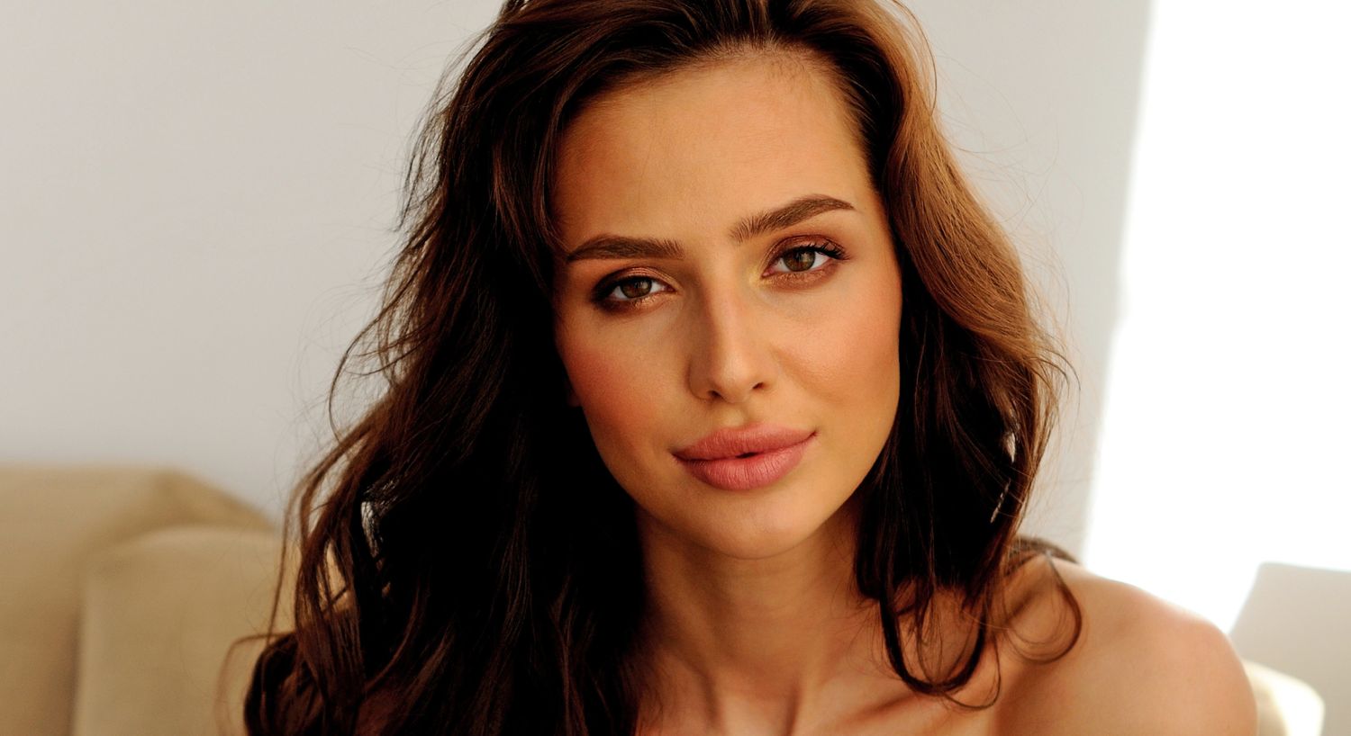 Woman with long hair, natural makeup, soft expression.